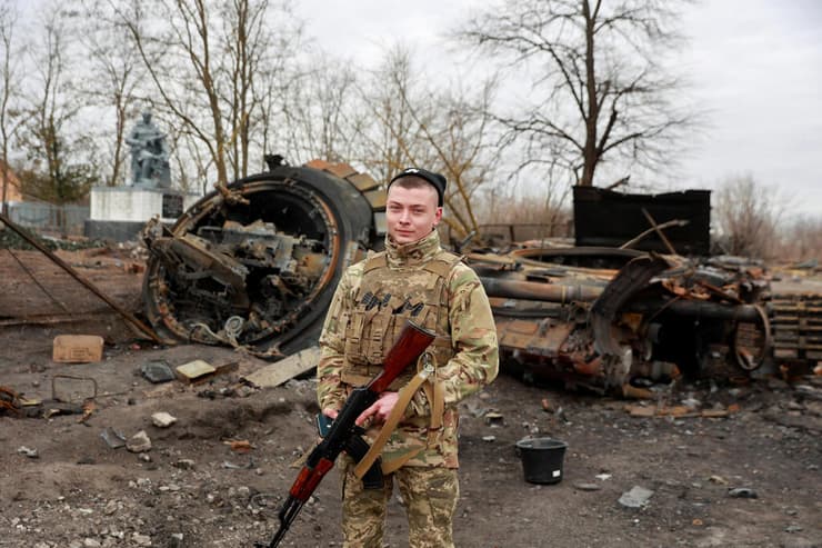 חייל אוקראיני ליד כלי רכב רוסים הרוסים ליד קייב