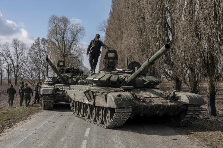 בכפר מחוץ לקייב חיילים אוקראינים נוהגים בטנק רוסי שנתפס משבר מלחמה רוסיה אוקראינה 