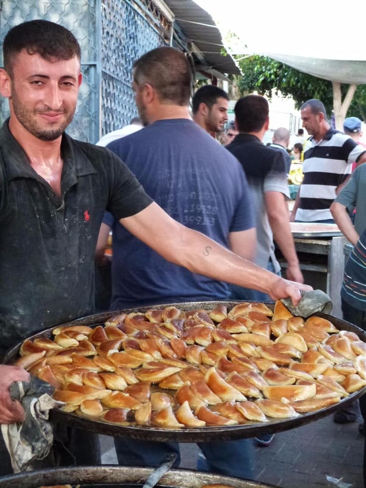עוברים בין חנויות ודוכני האוכל בישובים הערביים