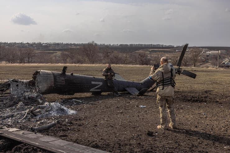 חייל אוקראיני ליד שרידי מסוק רוסי