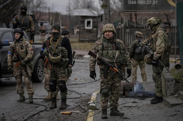 חיילים ב צבא אוקראינה ליד גופה של הרוג בעיירה בוצ'ה באזור קייב