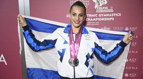 אשרם עם המדליות ודגל ישראל אחרי עוד אליפות עולם מוצלחת