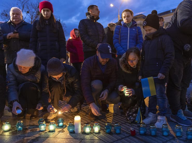 מדליקים נרות לזכר קורבנות טבח בוצ'ה ב לבוב אוקראינה מלחמה עם רוסיה
