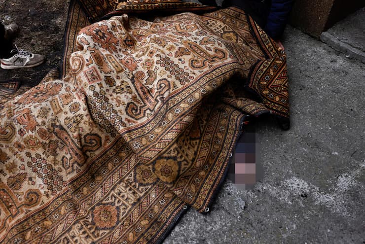 גופה של אדם בשם איגור ליטביננקו שנהרג על ידי כוחות רוסיה מכוסה בשטיח ב בוצ'ה אוקראינה