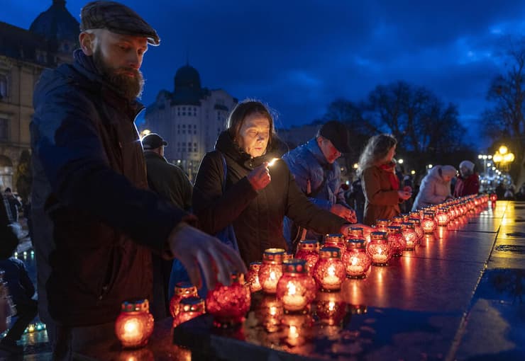 מדליקים נרות לזכר קורבנות טבח בוצ'ה ב לבוב אוקראינה מלחמה עם רוסיה