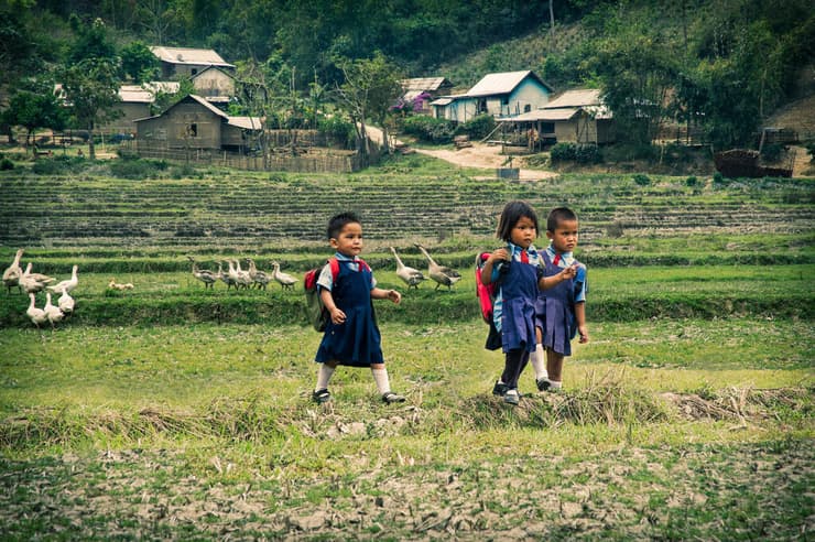 ילדות חוצות את שדות האורז בדרכן לבית הספר. בני מנשה באזור חיים סביב עונות השנה, שהן גם מחזור הצמיחה של לחמם