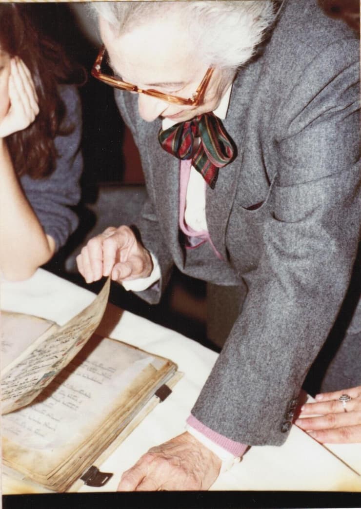 אליזבת, האחות הבכורה של לודוויג ויוהנה מארום, מעלעלת בהגדה במהלך ביקורה במוזיאון ישראל ב־1984