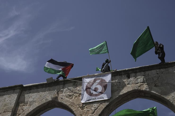 פלסטינים מנופפים בדגלי פלסטין וחמאס בהר הבית