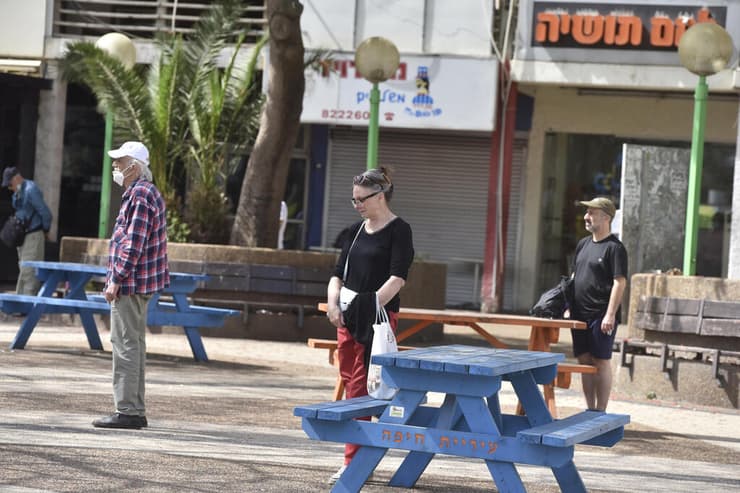  אנשים עומדים בצפירה בחיפה 