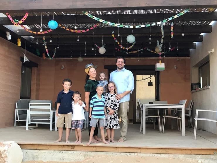 רייצ'ל ואדם הופקינס עם ילדיהם בביתם החדש ברתמים. 