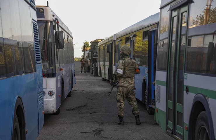 אוקראינה מריופול מורדים פרו רוסים מחכים ליד אוטובוסים שיפנו חיילים אוקראינים מ אזובסטל ל שטח בשליטת רוסיה