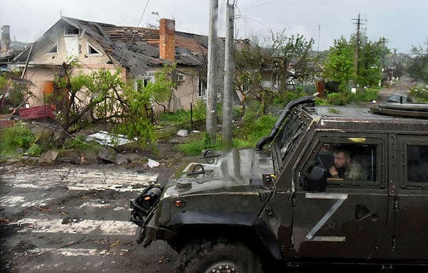 אוקראינה רכב צבאי רוסי ליד בית הרוס ב מריופול