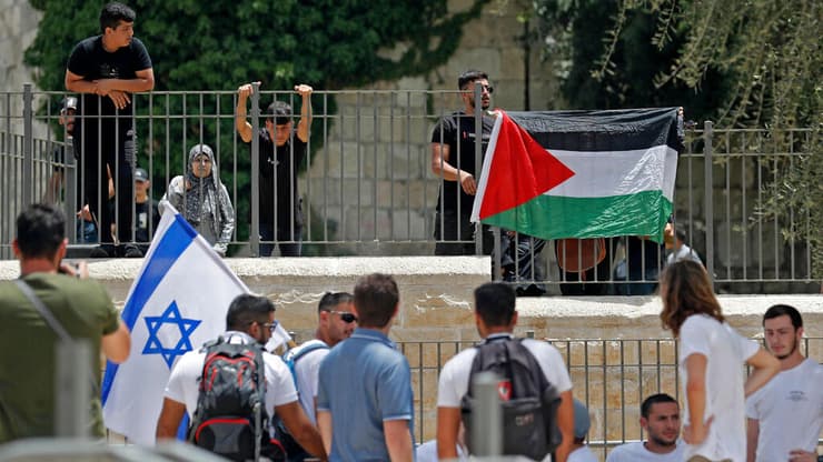 מפיגינים עם דגלי ישראל ולפסטין ליד שער שכם