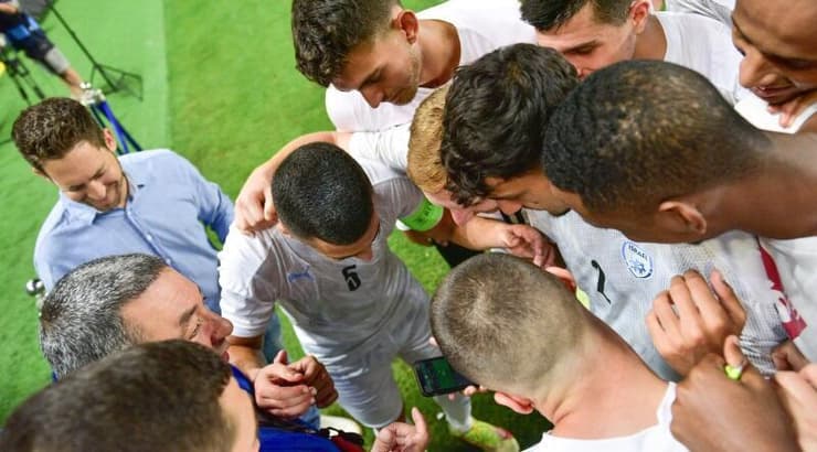 שחקני נבחרת ישראל הצעירה צופים בסיום המשחק של פולין