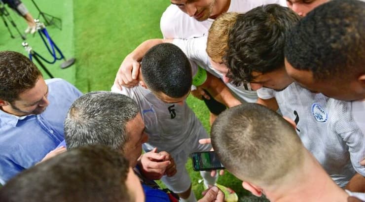 שחקני נבחרת ישראל הצעירה צופים בסיום המשחק של פולין