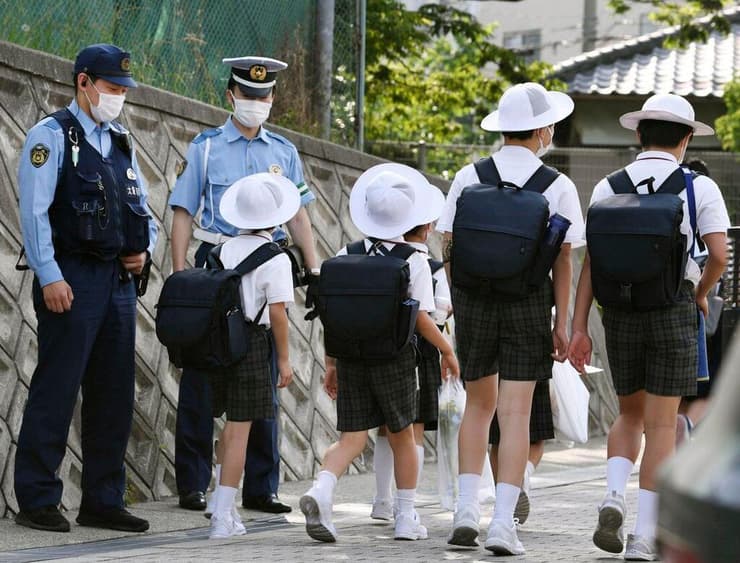 תלמידים בבית הספר באיקדה, מאובטחים על ידי שוטרים
