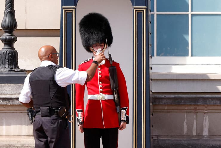 שומר מחוץ ל ארמון בקינגהאם ב לונדון שותה מים ב גל חום בריטניה