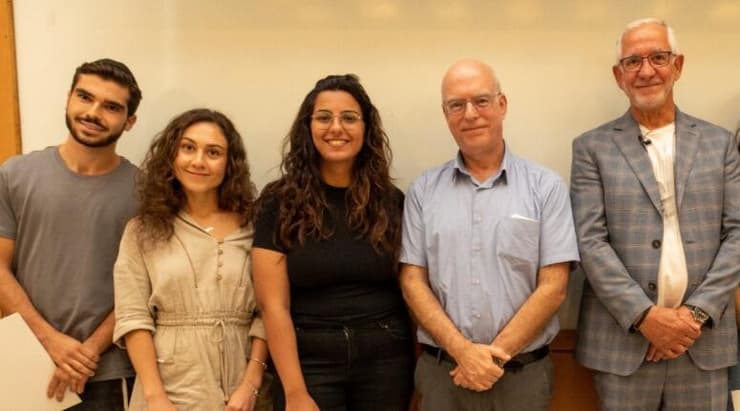 נשיא אוניברסיטת תל אביב, פרופ' אריאל פורת, לצד התורם חיים טייב וכמה מהסטודנטים