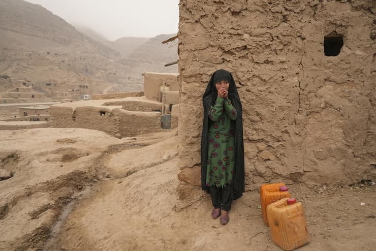 צעירה לוקחת הפוגה מנשיאת מים באפגניסטאן