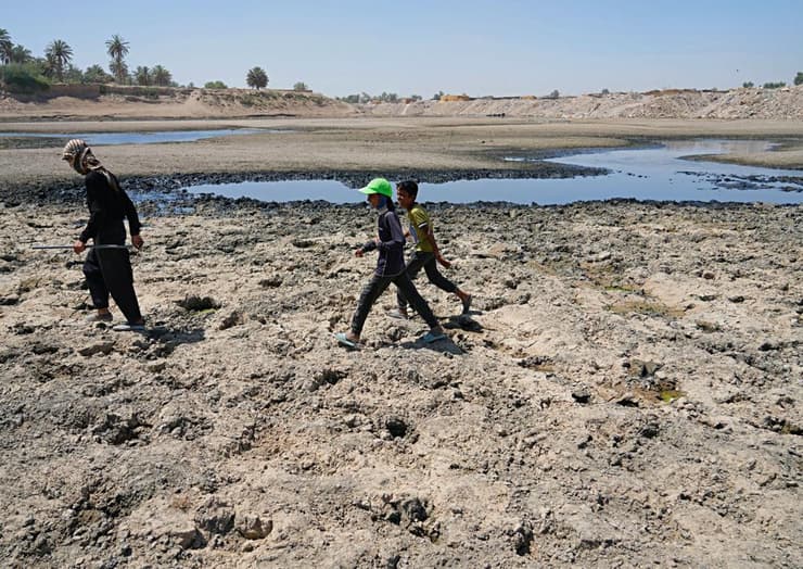 צעירים חוצים נהר יבש בעיראק