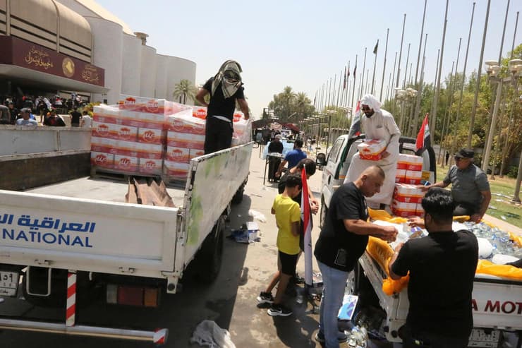 עיראק מתנדבים מביאים אוכל ומים לתומכי איש הדת מוקתדא א-סדר שמתבצרים ב פרלמנט ב בגדד