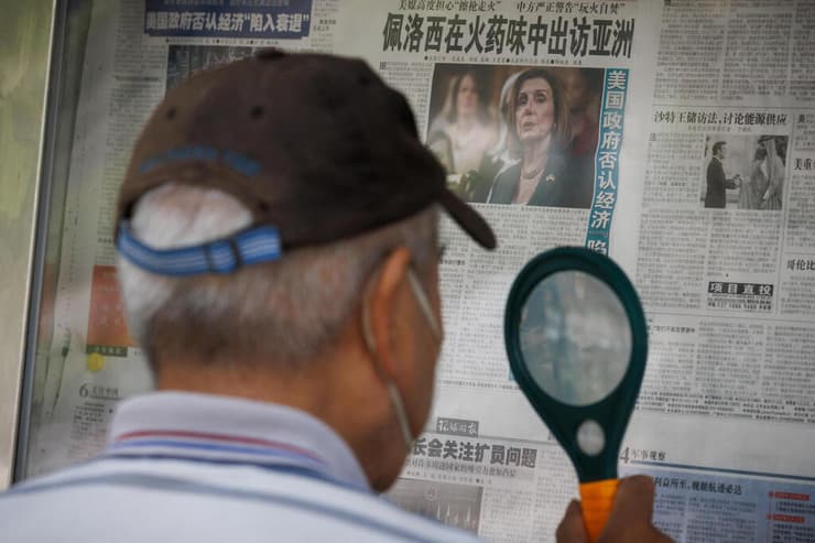 גבר סיני קורא דיווח על הביקור המתוכנן של ננסי פלוסי ב טייוואן בעיתון גלובל טיימס ב בייג'ינג סין