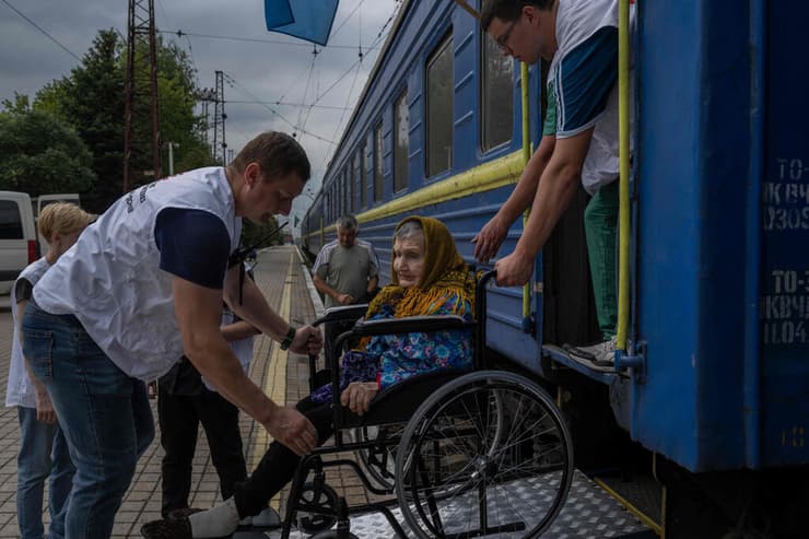 אוקראינה אנשי ארגון רופאים ללא גבולות מעלים אישה זקנה לרכבת פינוי מ דונייצק