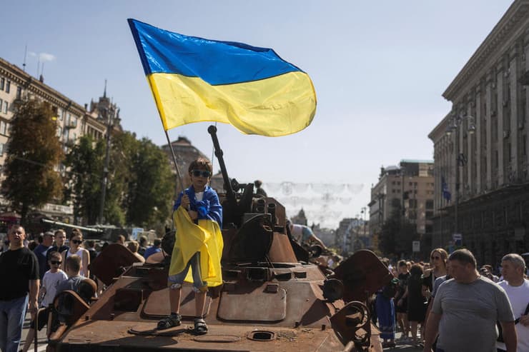 אוקראינה ילד מצטלם עם נגמ"ש רוסי הרוס ב בירה קייב לפני יום העצמאות