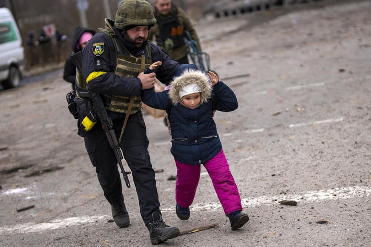 השוטר האוקראיני רוסלאן חוסיינב מסייע בפינוי פליטים מ אירפין בחודש מרץ 2022  מלחמה אוקראינה רוסיה