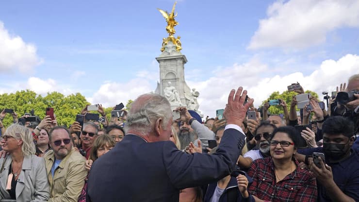 המלך צ'רלס לוחץ ידיים קהל ליד ארמון בקינגהאם לונדון בריטניה