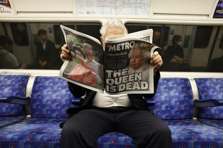 בריטניה מות המלכה אליזבת השנייה קוראים דיווחים בעיתון ב רכבת