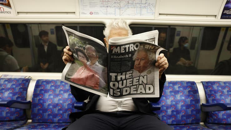 בריטניה מות המלכה אליזבת השנייה קוראים דיווחים בעיתון ב רכבת