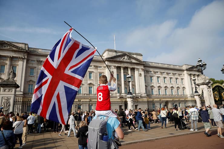 ילד עם דגל בריטניה ליד ארמון בקינגהאם