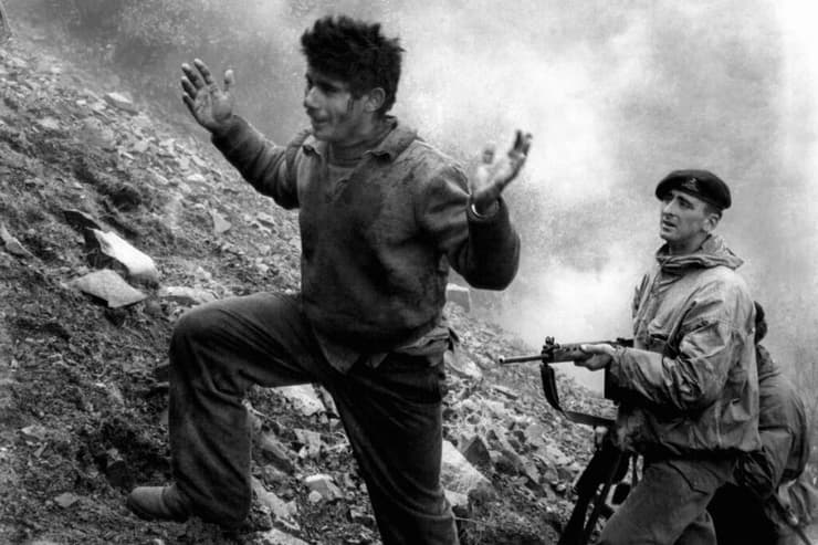 חיל בריטי מוביל איש מחתרת ב קפריסין ב-1957 מתוך מערת מחבוא שבה נתפס בהרי טרודוס קולוניאליזם
