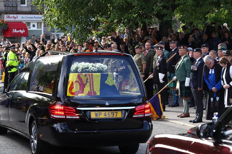 שיירה רכבים עם ארונה של המלכה אליזבת עוברת ברחובות סקוטלנד מסע ארון הקבורה בריטניה 