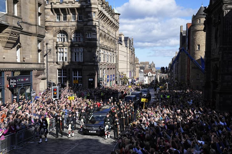 קהל מביט על ארון המלכה אליזבת עטוף ב דגל סקוטלנד אדינבורו בריטניה