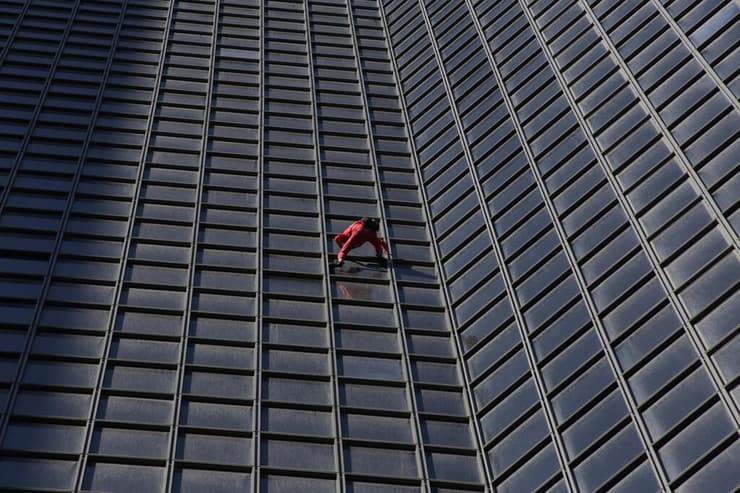 טיפוס אלו רובר שמוכר כ הספיידרמן הצרפתי מטפס על מגדל גורד שחקים ב פריז צרפת