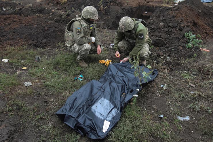 חיילים אוקראינים אוספים גופה של חייל אוקראיני שנהרג בקרבות באזור חרקוב לא הרחק מגבול רוסיה מלחמה אוקראינה