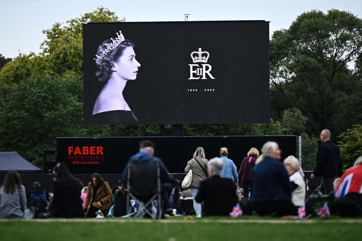 אנשים בהייד פארק לונדון מתכנסים לצפות בהלווית המלכה אליזבת השנייה שתוקרן על מסכים