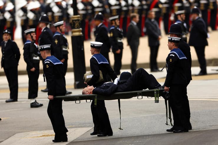 מפנים באלונקה שוטר שהתעלף ב לונדון בריטניה במהלך הלוויה ל המלכה אליזבת