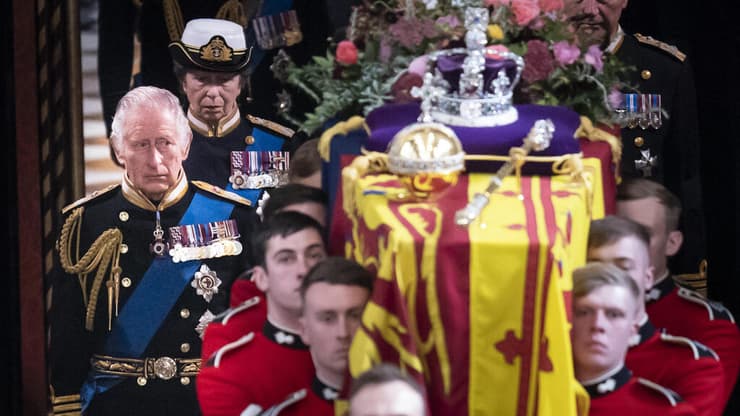 המלך צ'רלס צועד מאחור ארון אמו המלכה אליזבת הלוויה ב כנסיית מנזר ווסטמינסטר לונדון בריטניה