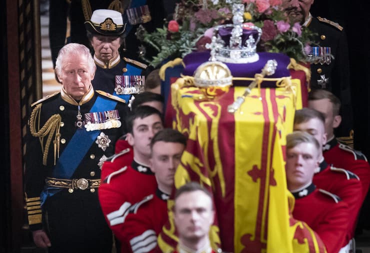 המלך צ'רלס צועד מאחור ארון אמו המלכה אליזבת הלוויה ב כנסיית מנזר ווסטמינסטר לונדון בריטניה