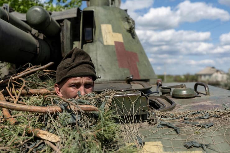 חייל של צבא אוקראינה מציץ מ טנק בעיירה לימאן מחוז דונייצק חודש אפריל