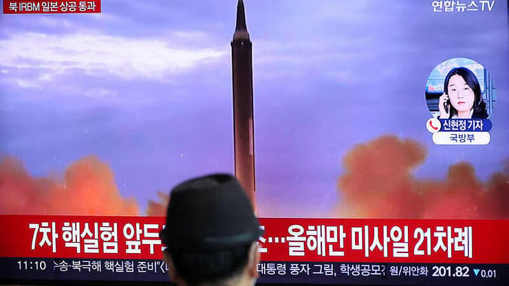 יפנים צופים בדיווחים אודות שיגור הטיל של צפון קוריאה שחלף מעל יפן