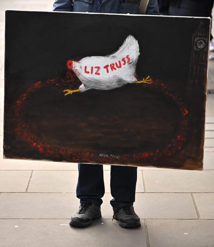 מפגין עם שלט נגד ראש ממשלת בריטניה ליז טראס ב  לונדון 19 באוקטובר