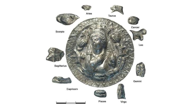 מדליון הכסף עם דמותה של אפרודיטה וסביבה סמליהם של 10 מתוך 12 המזלות בגלגל המזלות