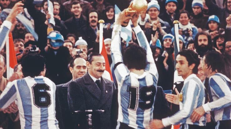 גנרל וידלה צופה בקפטן ארגנטינה דניאל פסארלה מניף את הגביע במונדיאל הביתי ב-1978