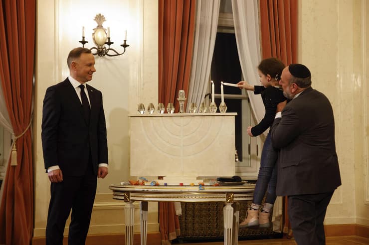 נשיא פולין, אנדז'יי דודה, צופה ברב מיכאל שודריך ובבתו חנה אליס בהדלקה