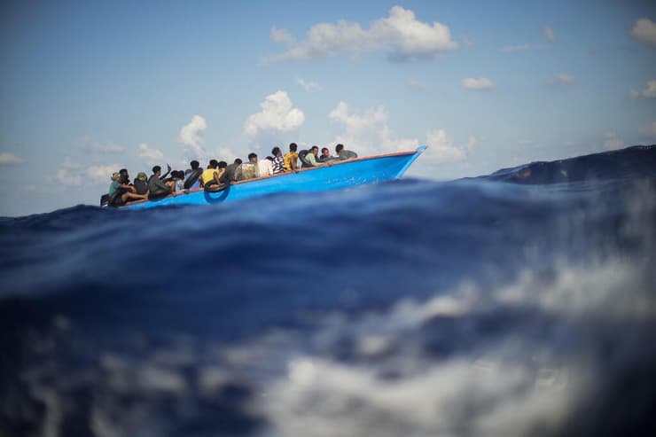 תמונות השנה 2022 מהגרים שטים בסירה לעבר האי למפדוזה איטליה אוגוסט