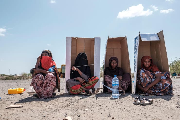 תמונות השנה 2022 נשים מסתתרות מהשמש בקרטונים במתחם סיוע של האו"ם ב אתיופיה